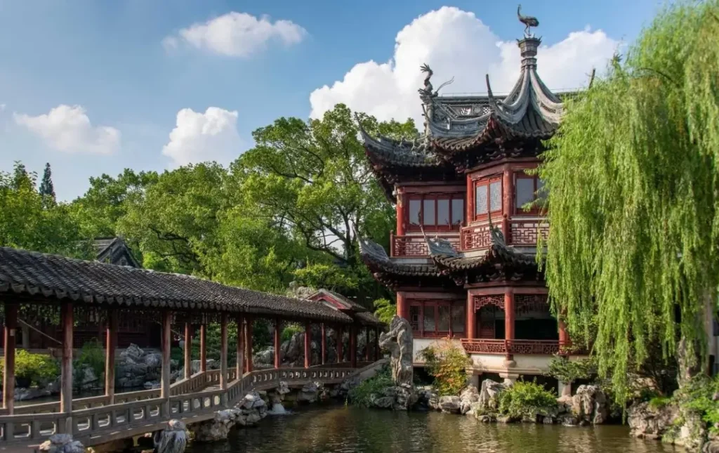 traditional chinese pavilion and bridge inside yuyuan garden in shanghai surrounded by greenery