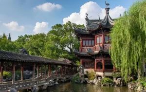 traditional chinese pavilion and bridge inside yuyuan garden in shanghai surrounded by greenery