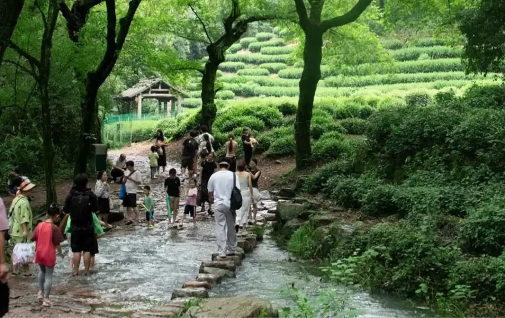 Visitors walking across stream at Nine Creeks Hangzhou