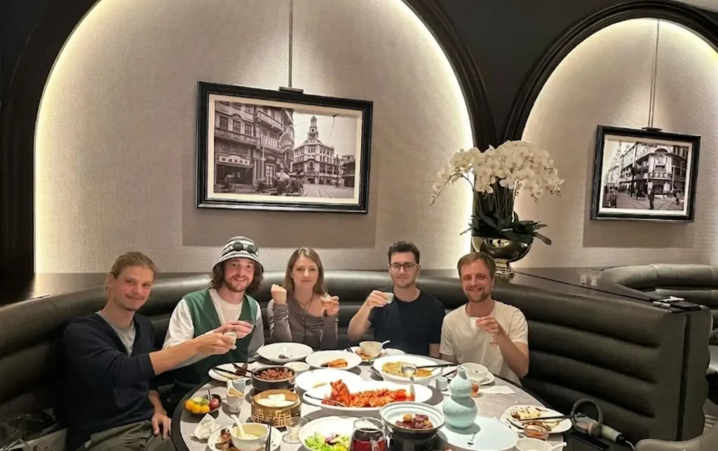 tourists enjoying a local chinese meal in shanghai restaurant during cultural tour