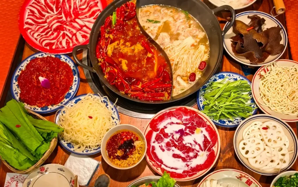 Authentic Chengdu Sichuan hotpot feast spread with fresh ingredients overhead view