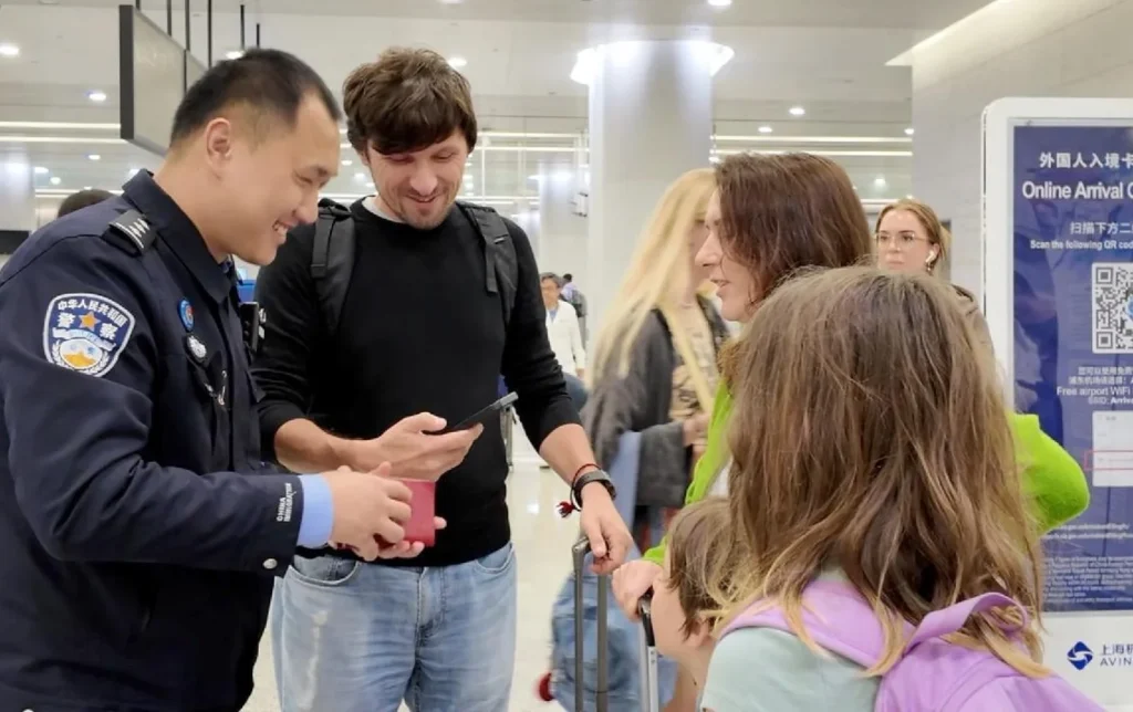 Chinese airport police officer helping foreign tourists with arrival card at airport