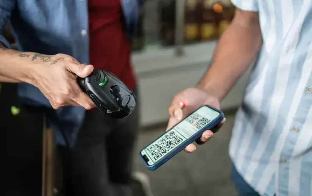 A tourist scanning a QR code on their smartphone for cashless mobile payment at a venue in China