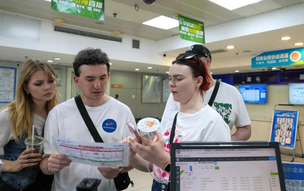 Foreign tourists registering China SIM card and mobile services at a telecom counter in Beijing