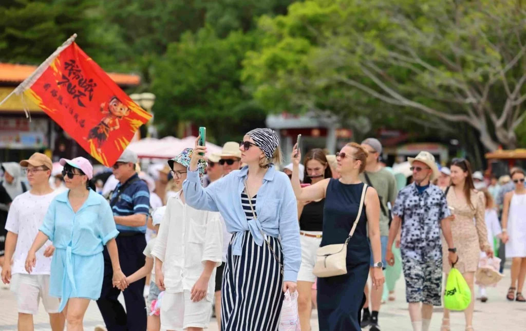 Foreign tourists sightseeing and taking selfies in Hainan China as the visa-free travel policy drives inbound tourism growth