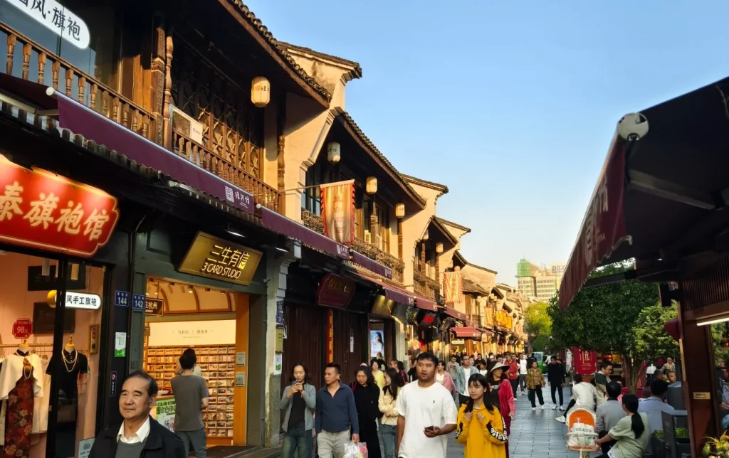 Hangzhou Hefang Street traditional shophouses and pedestrian zone with local visitors at golden hour