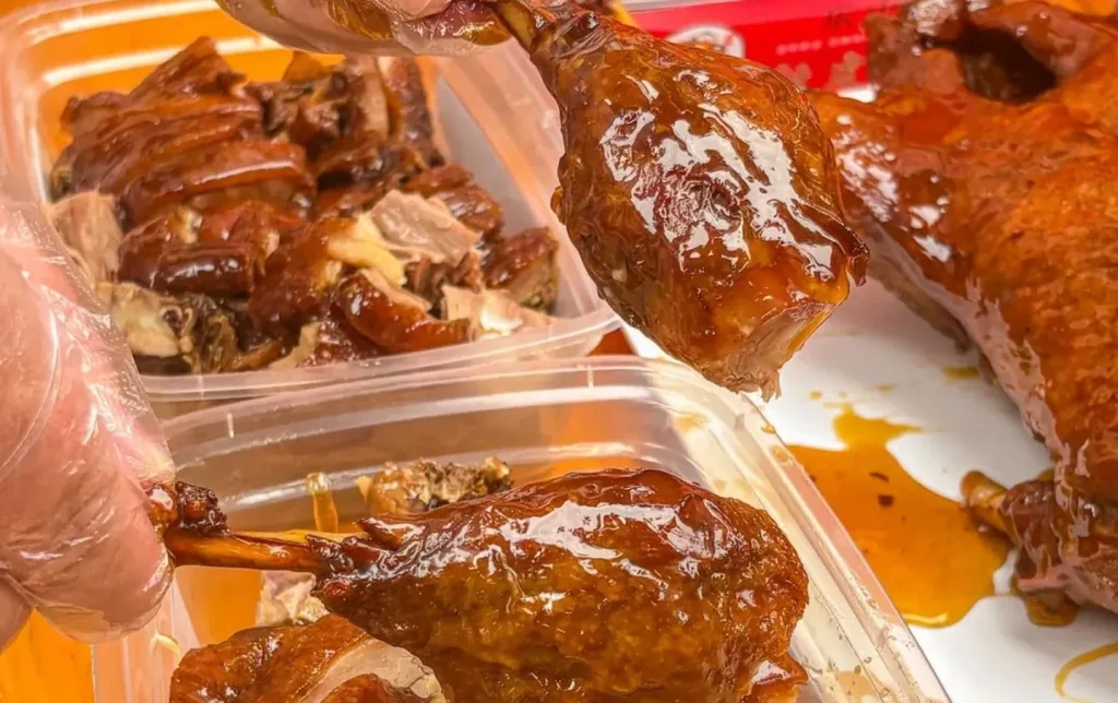 Leshan sweet skin roast duck chopped and served in takeaway container with caramel glaze Sichuan food