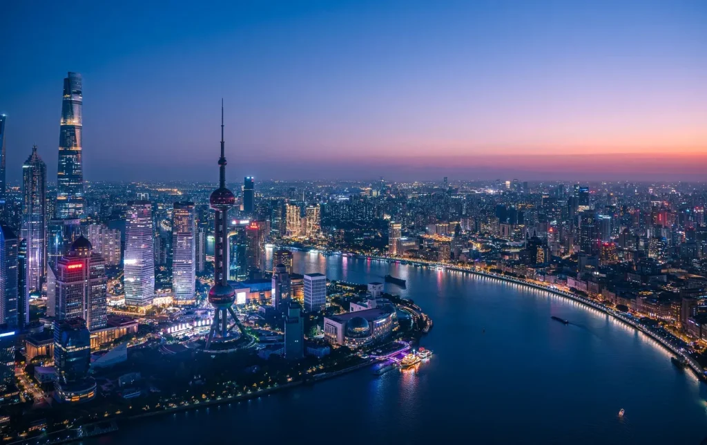 Sweeping blue-hour aerial panorama of Shanghai's Pudong skyline with the Oriental Pearl Tower and Huangpu River — Shanghai skyline photography