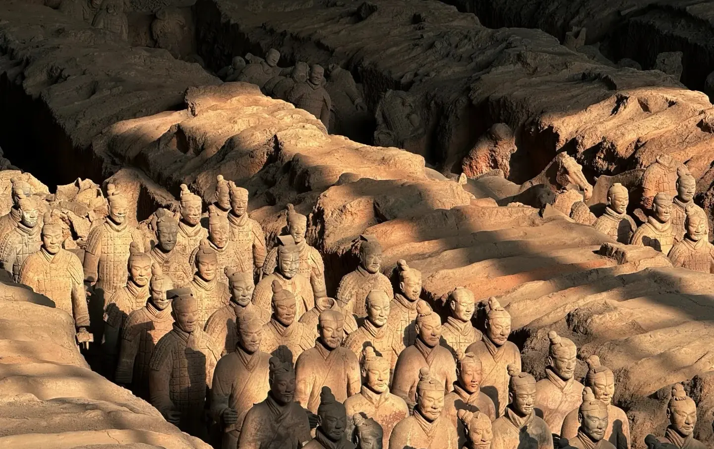 Panoramic view of hundreds of life-size Qin dynasty terracotta warriors standing in earth-walled corridors in Pit 1 of the First Emperor's Mausoleum, Xi'an, a UNESCO World Heritage Site