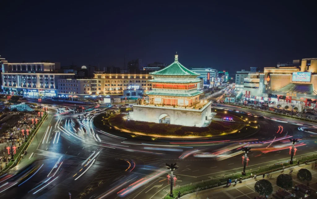 Xi'an Bell Tower illuminated at night with long-exposure traffic light trails a must-visit landmark for tourists traveling to China