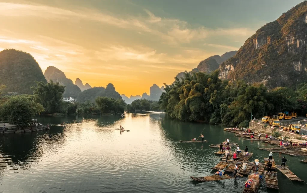 tour.webpGolden sunset over Yulong River with bamboo rafts and dramatic karst mountain peaks in Yangshuo, Guilin, China travel destination