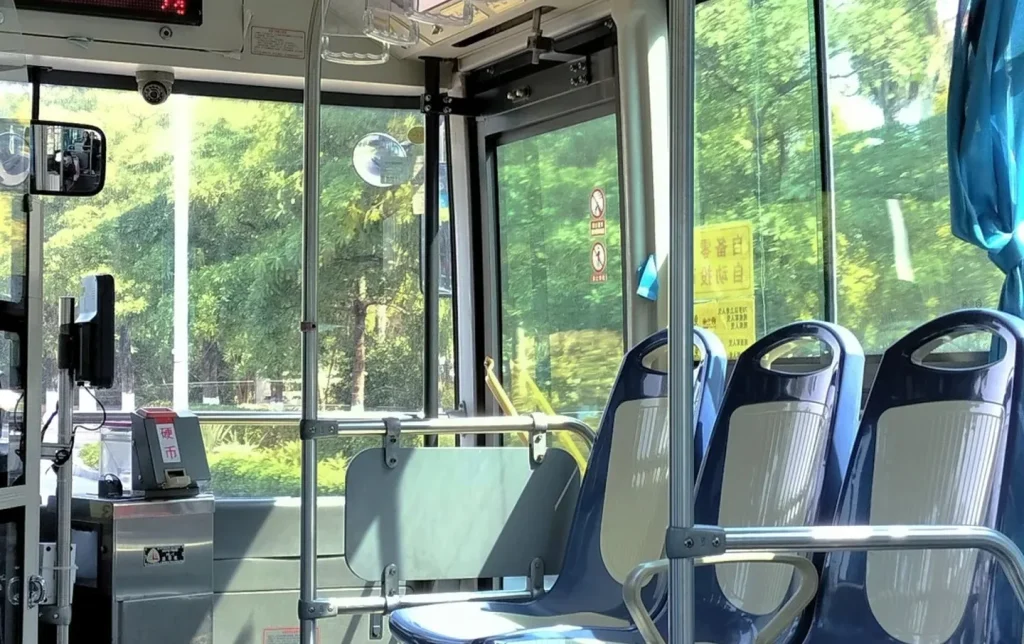 Bright interior of a modern Chinese city bus with blue seats and open doors, a budget-friendly local transport option for China city tours